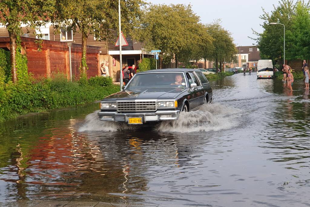 Jeugd vermaakt zich in ondergelopen straat