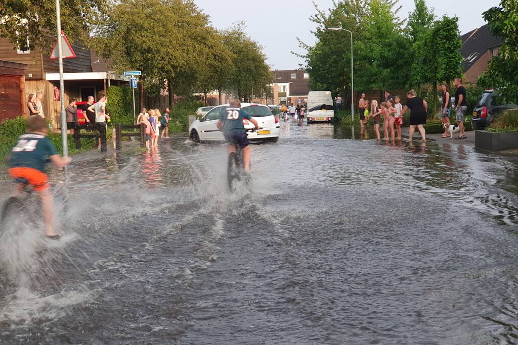 Jeugd vermaakt zich in ondergelopen straat