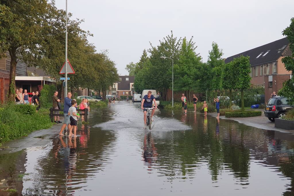 Jeugd vermaakt zich in ondergelopen straat