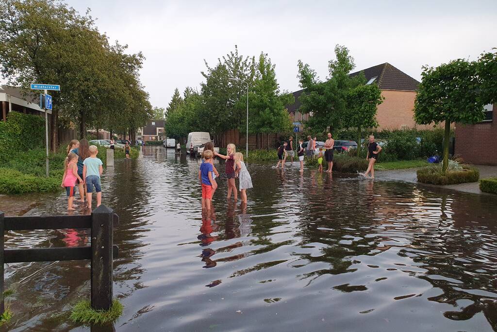Jeugd vermaakt zich in ondergelopen straat