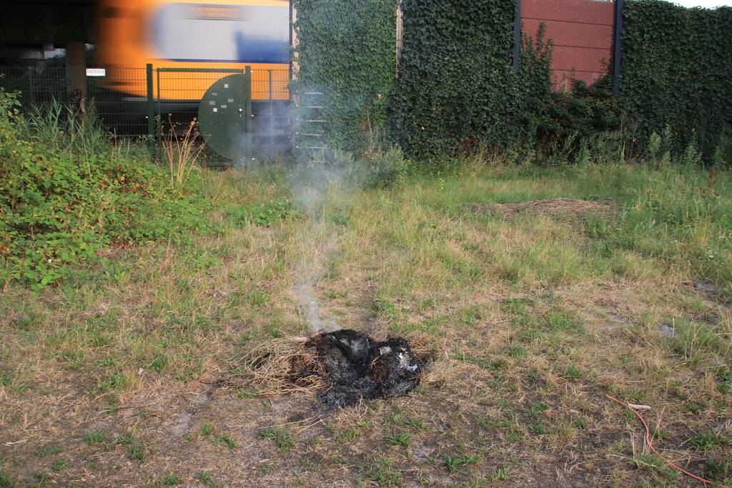 Buurtbewoner blust een hoop in brand gevlogen hooi