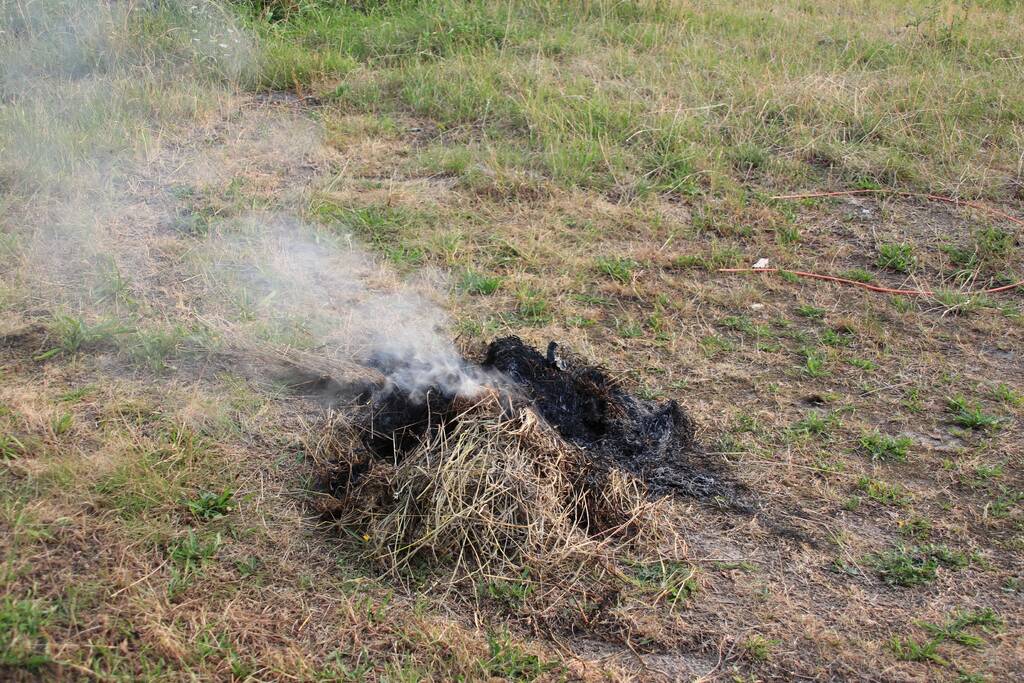 Buurtbewoner blust een hoop in brand gevlogen hooi