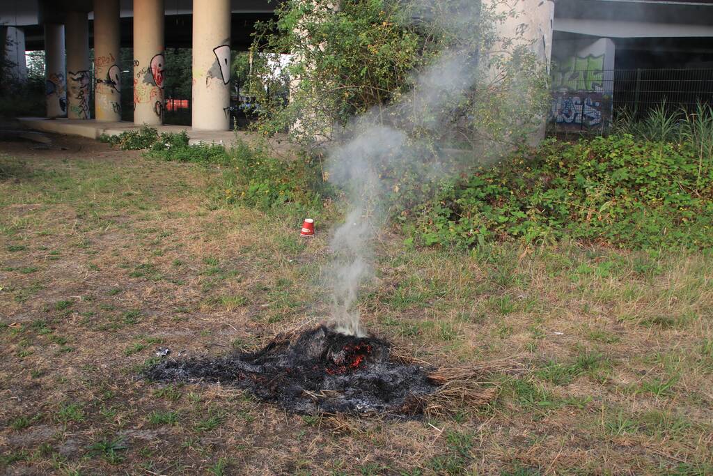 Buurtbewoner blust een hoop in brand gevlogen hooi