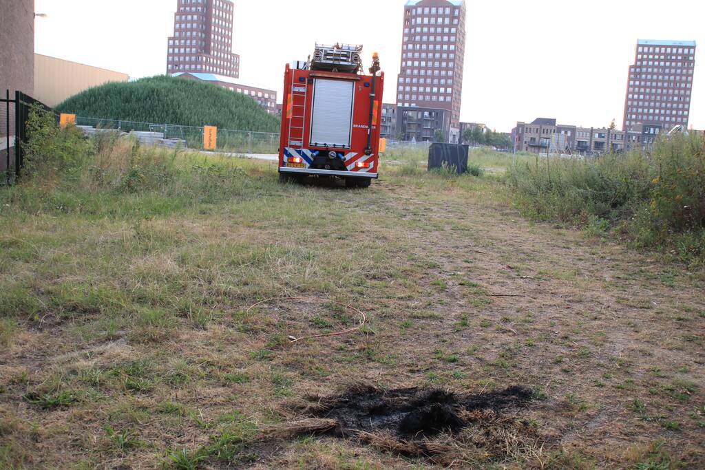 Buurtbewoner blust een hoop in brand gevlogen hooi