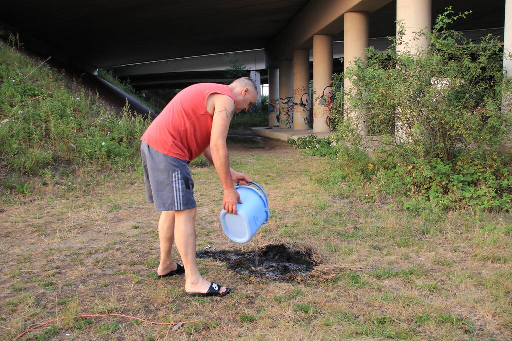 Buurtbewoner blust een hoop in brand gevlogen hooi