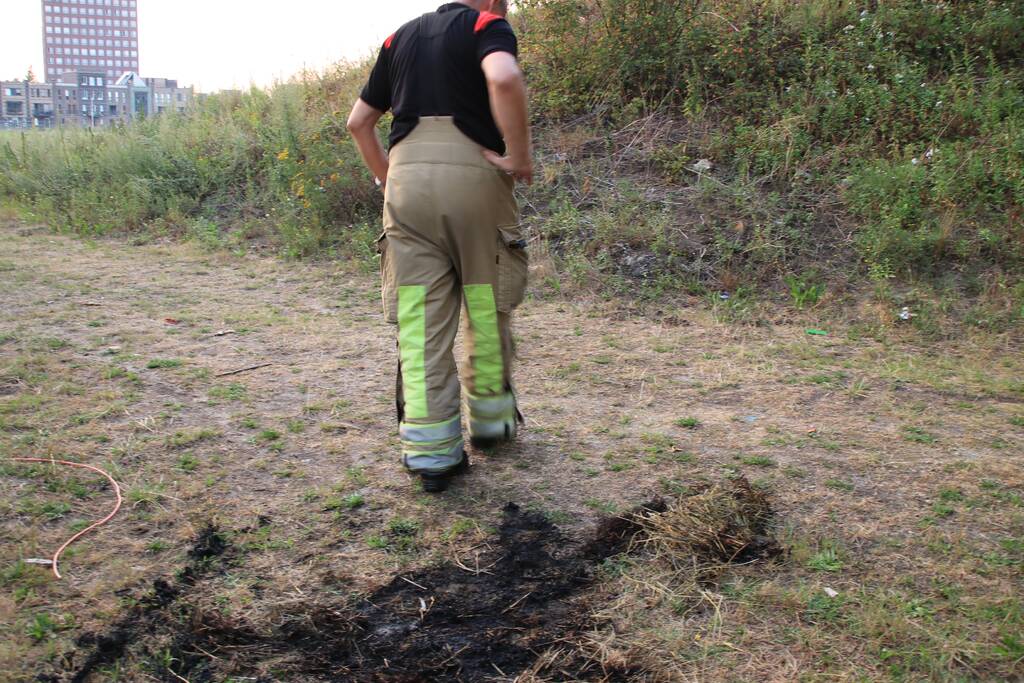 Buurtbewoner blust een hoop in brand gevlogen hooi
