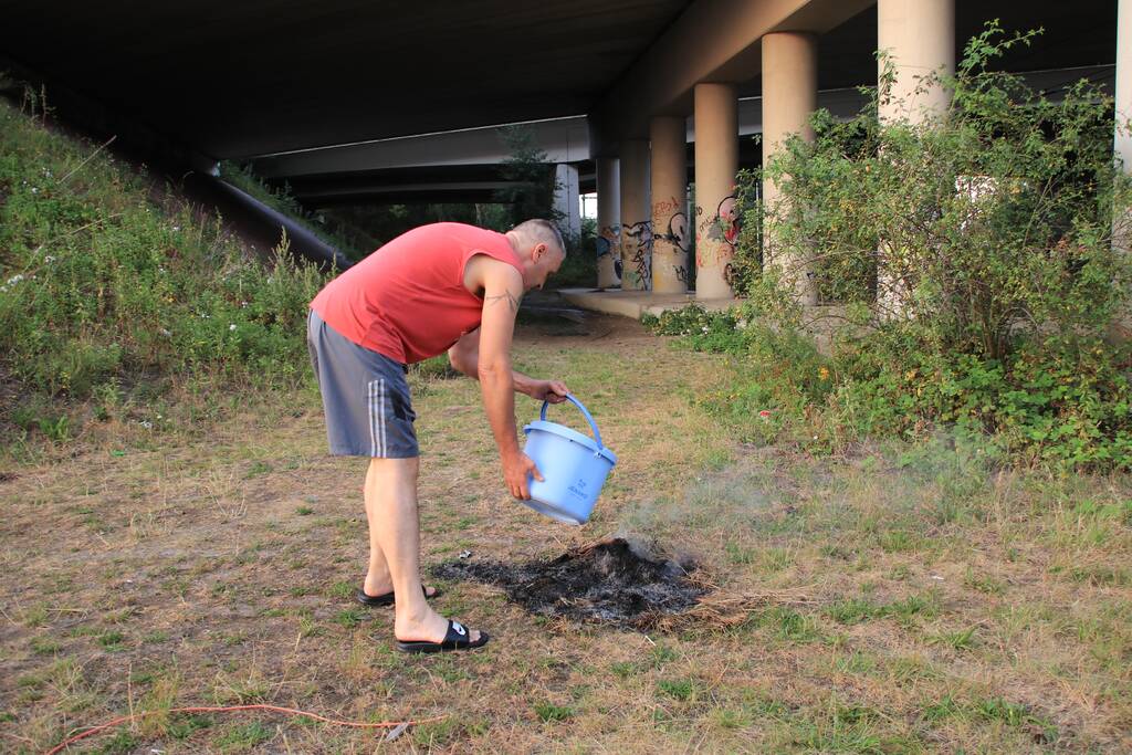 Buurtbewoner blust een hoop in brand gevlogen hooi