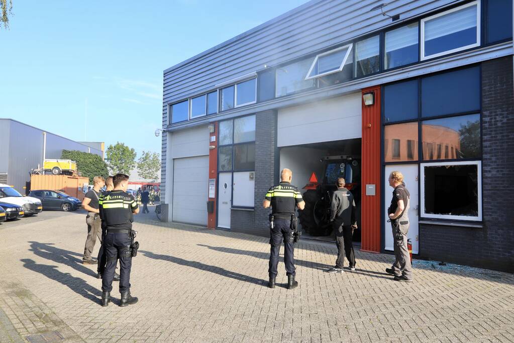 Medewerkers blussen brand in bedrijfsverzamelgebouw