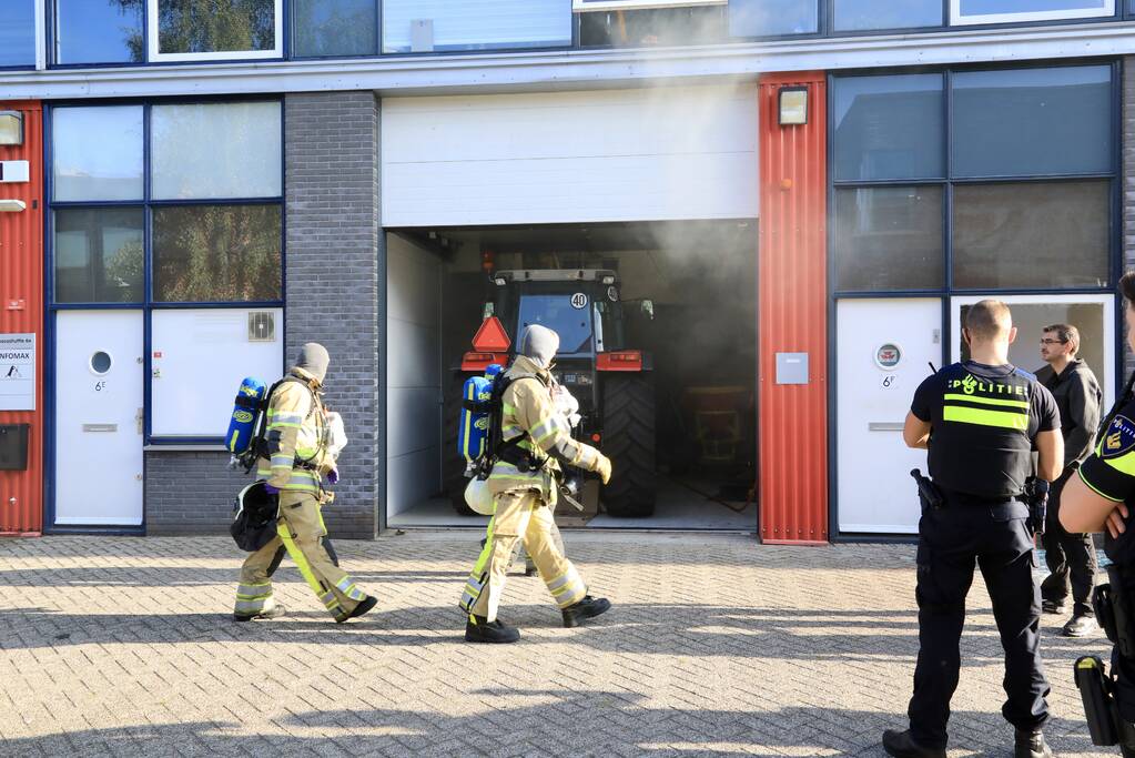 Medewerkers blussen brand in bedrijfsverzamelgebouw