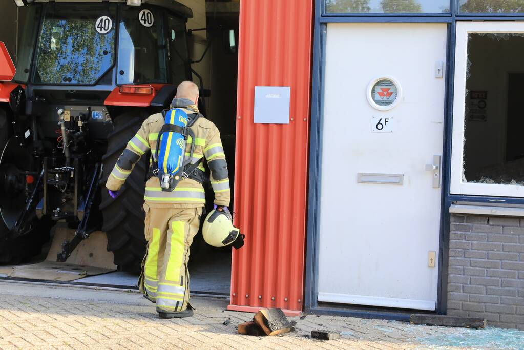 Medewerkers blussen brand in bedrijfsverzamelgebouw