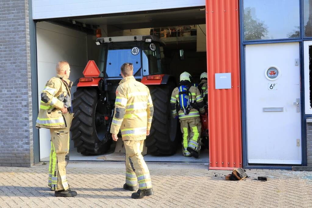 Medewerkers blussen brand in bedrijfsverzamelgebouw
