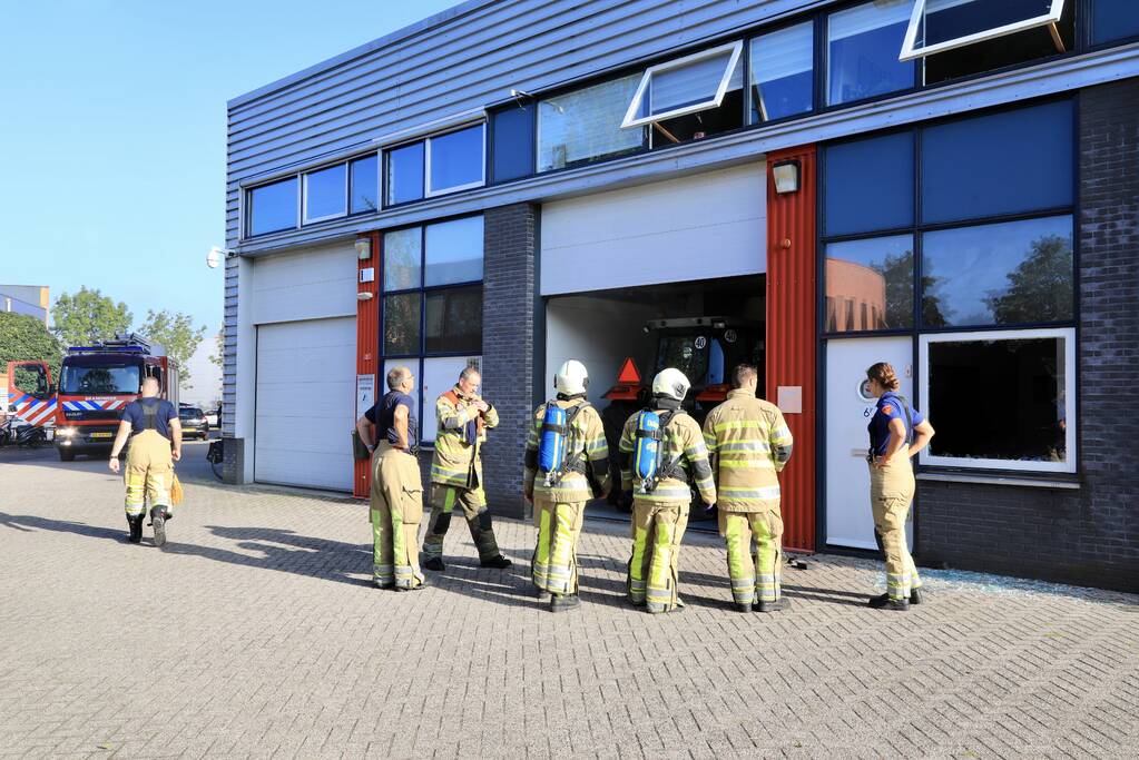 Medewerkers blussen brand in bedrijfsverzamelgebouw