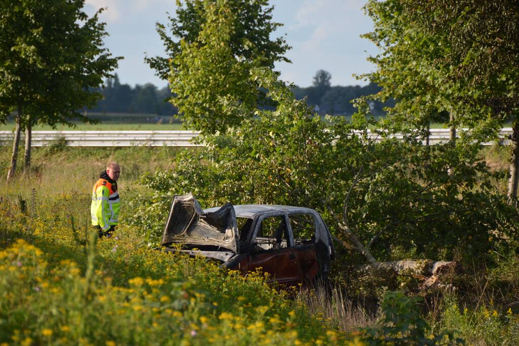 Auto belandt naast de snelweg en vliegt in brand