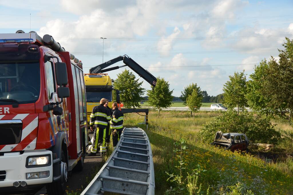 Auto belandt naast de snelweg en vliegt in brand