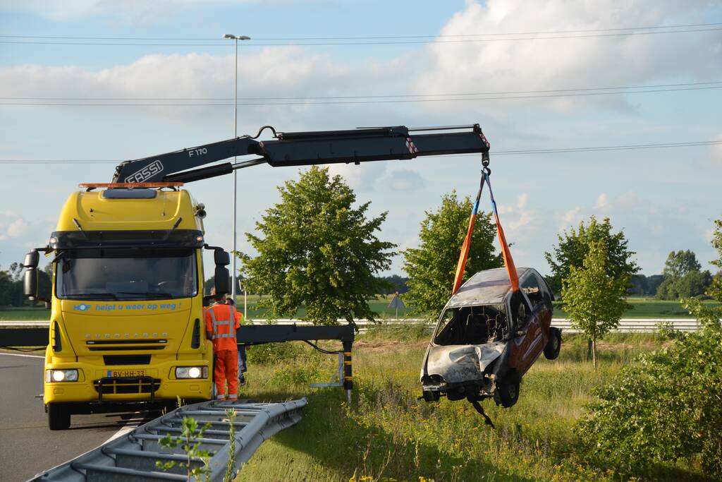 Auto belandt naast de snelweg en vliegt in brand