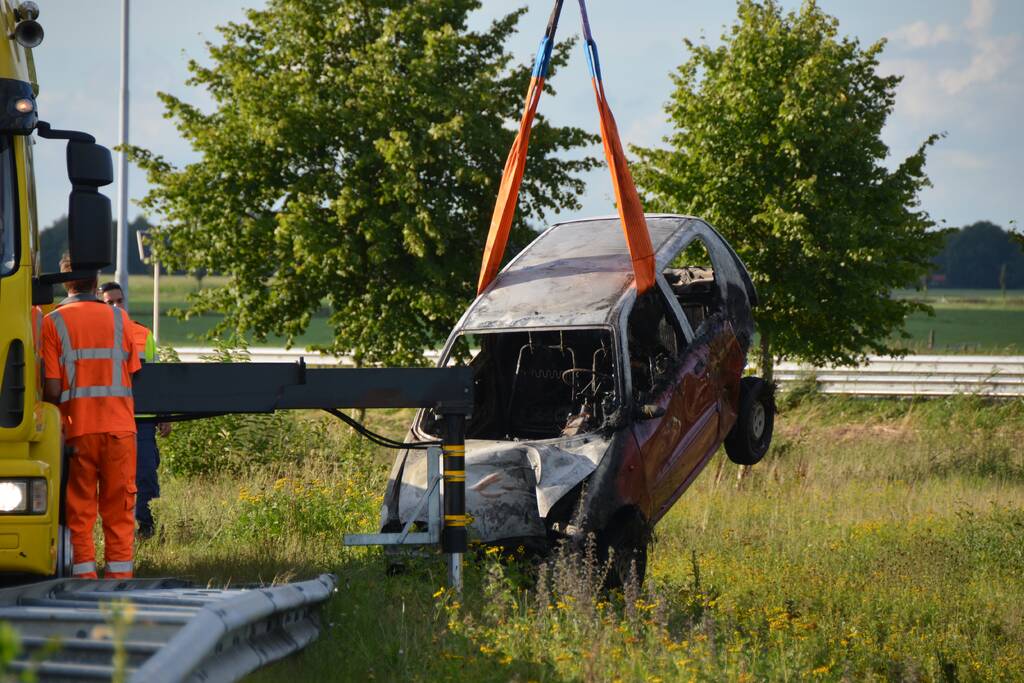 Auto belandt naast de snelweg en vliegt in brand