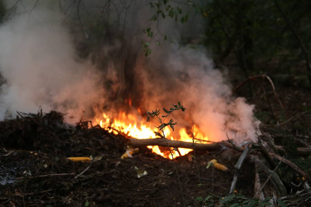 Berg afval in bos in brand gestoken