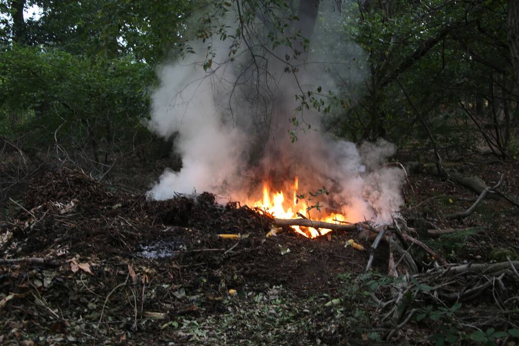 Berg afval in bos in brand gestoken