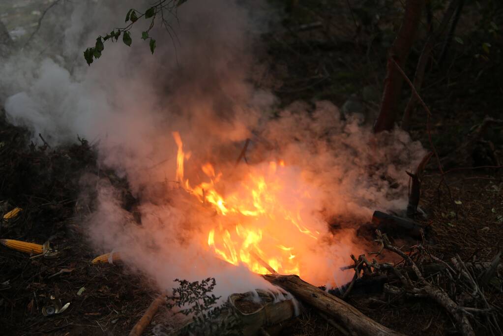 Berg afval in bos in brand gestoken