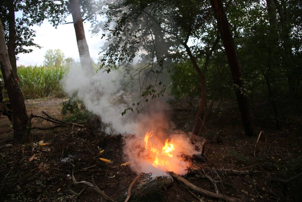 Berg afval in bos in brand gestoken
