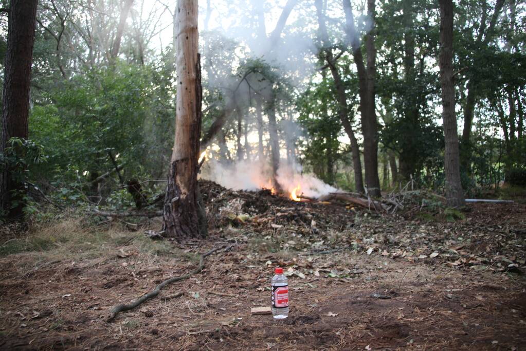 Berg afval in bos in brand gestoken