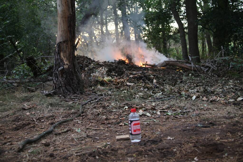 Berg afval in bos in brand gestoken