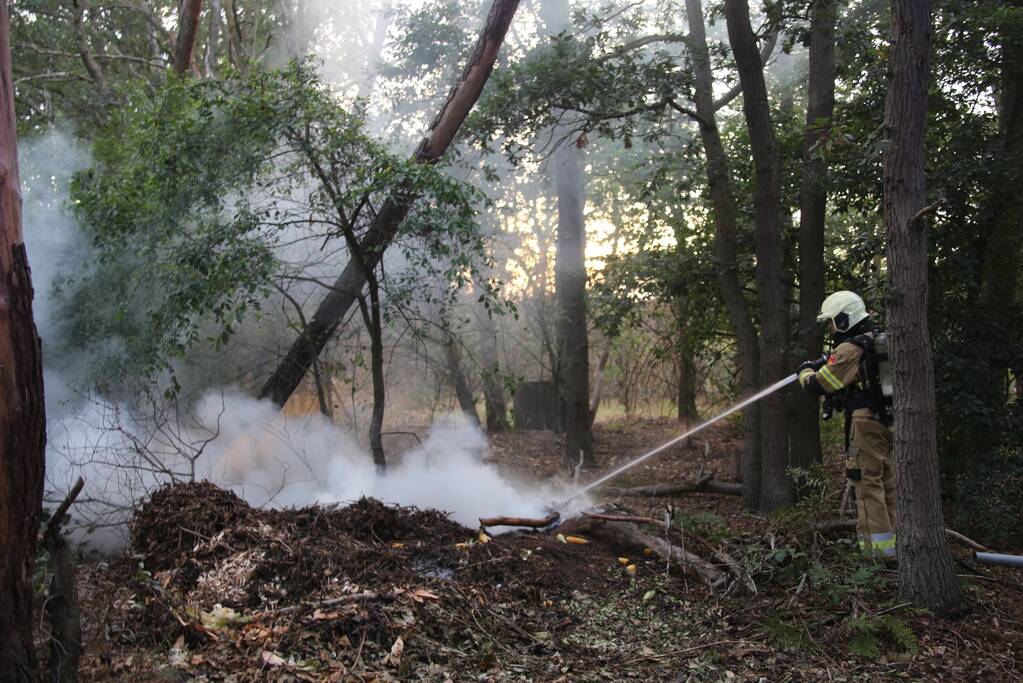 Berg afval in bos in brand gestoken