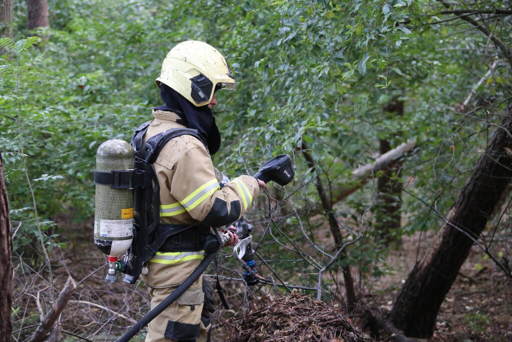 Berg afval in bos in brand gestoken