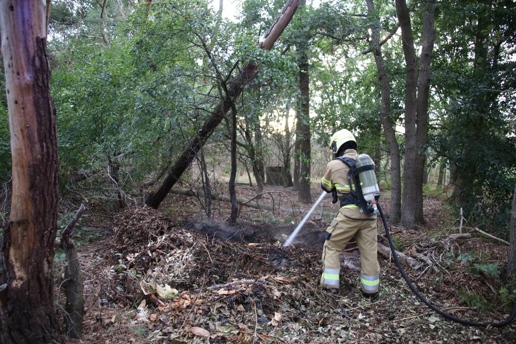 Berg afval in bos in brand gestoken