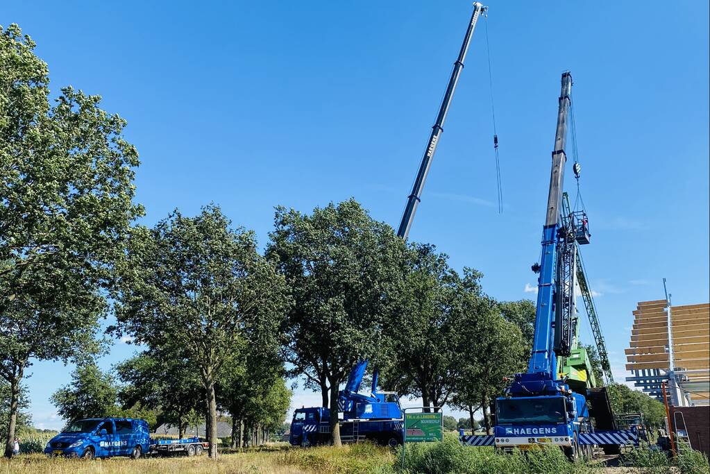 Bouwkraan achter stal omgevallen