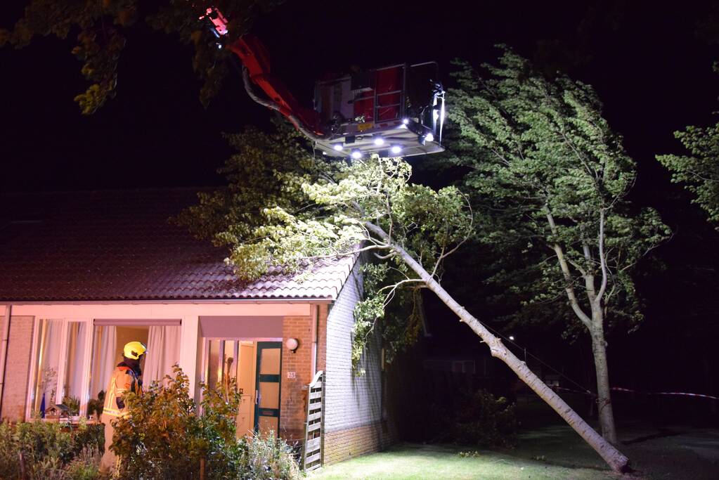 Boom waait om tegen woning