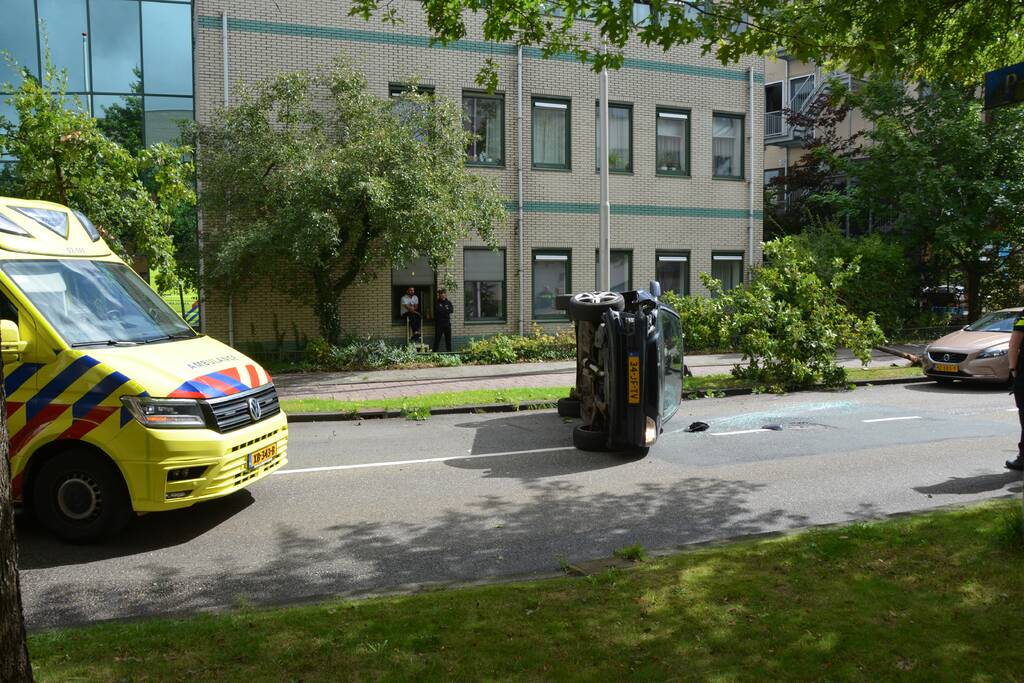 Auto vliegt uit de bocht en belandt op zijn kant