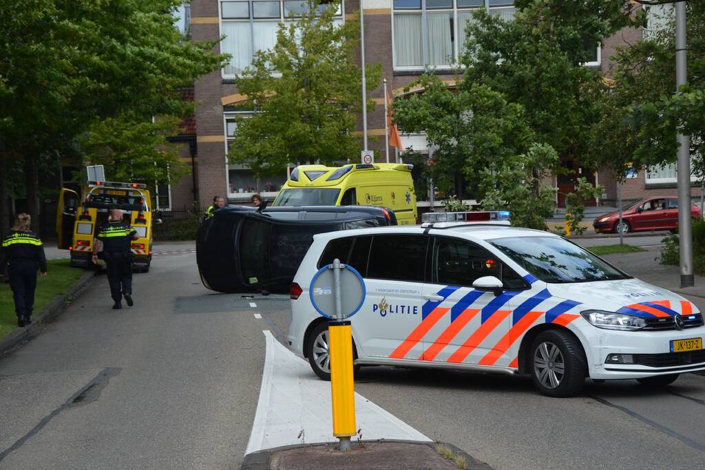 Auto vliegt uit de bocht en belandt op zijn kant