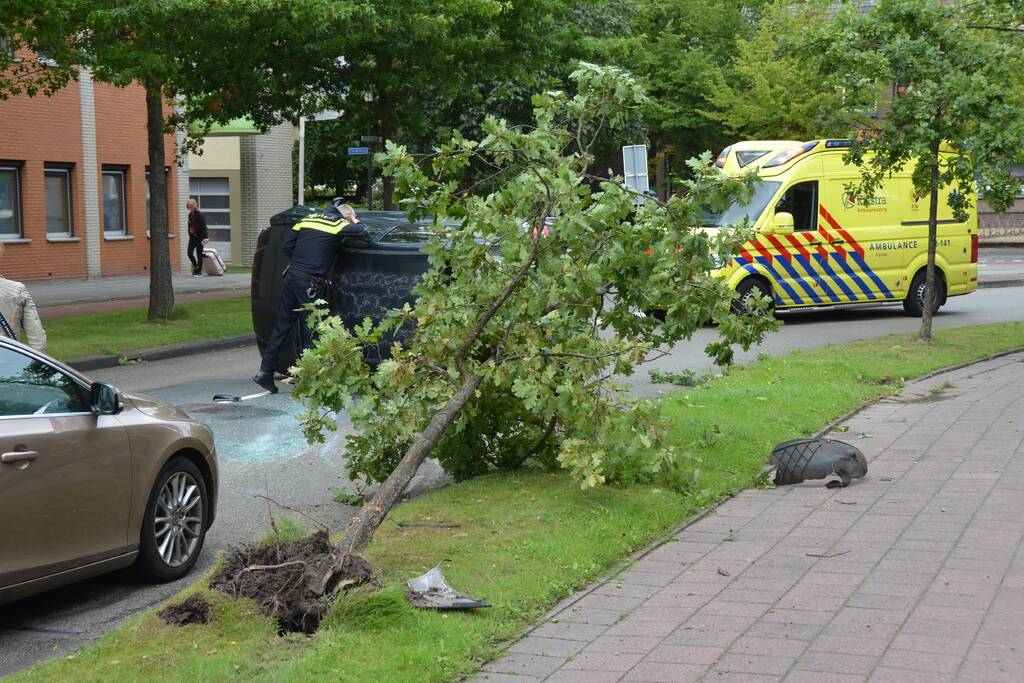 Auto vliegt uit de bocht en belandt op zijn kant