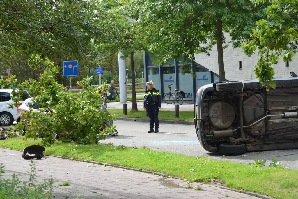 Auto vliegt uit de bocht en belandt op zijn kant