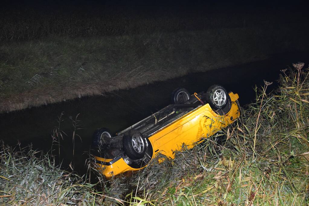 Auto belandt op de kop in het water