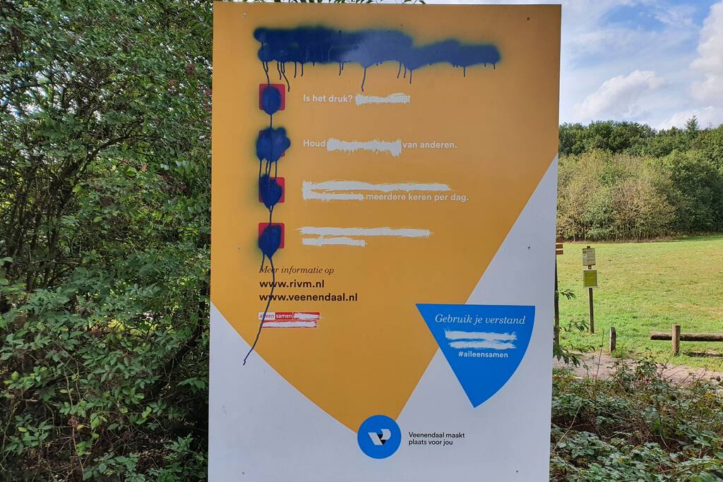 Corona COVID-19 waarschuwingsbord gemolesteerd bij bosrand
