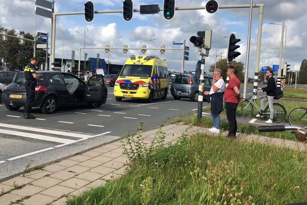 Twee auto's botsen op elkaar voor stoplicht