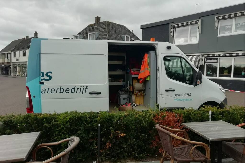 Straat opengebroken door gesprongen waterleiding
