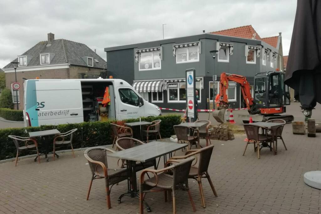 Straat opengebroken door gesprongen waterleiding