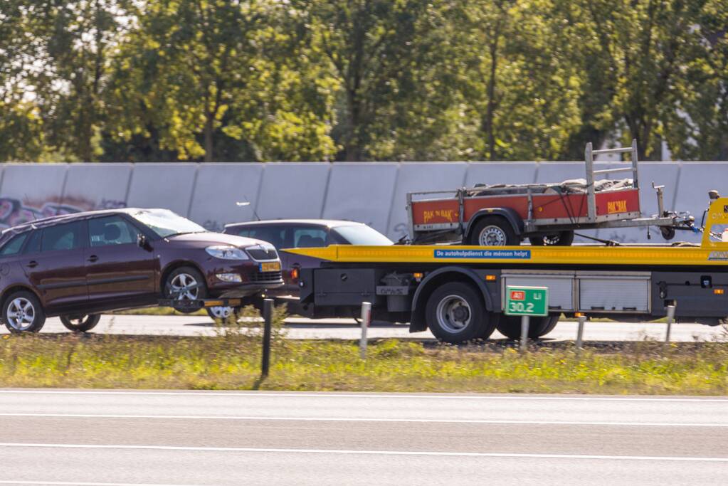 Auto met aanhanger geschaard op snelweg