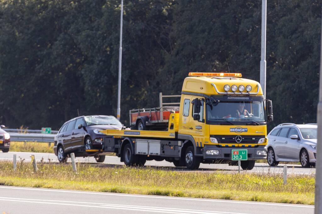 Auto met aanhanger geschaard op snelweg