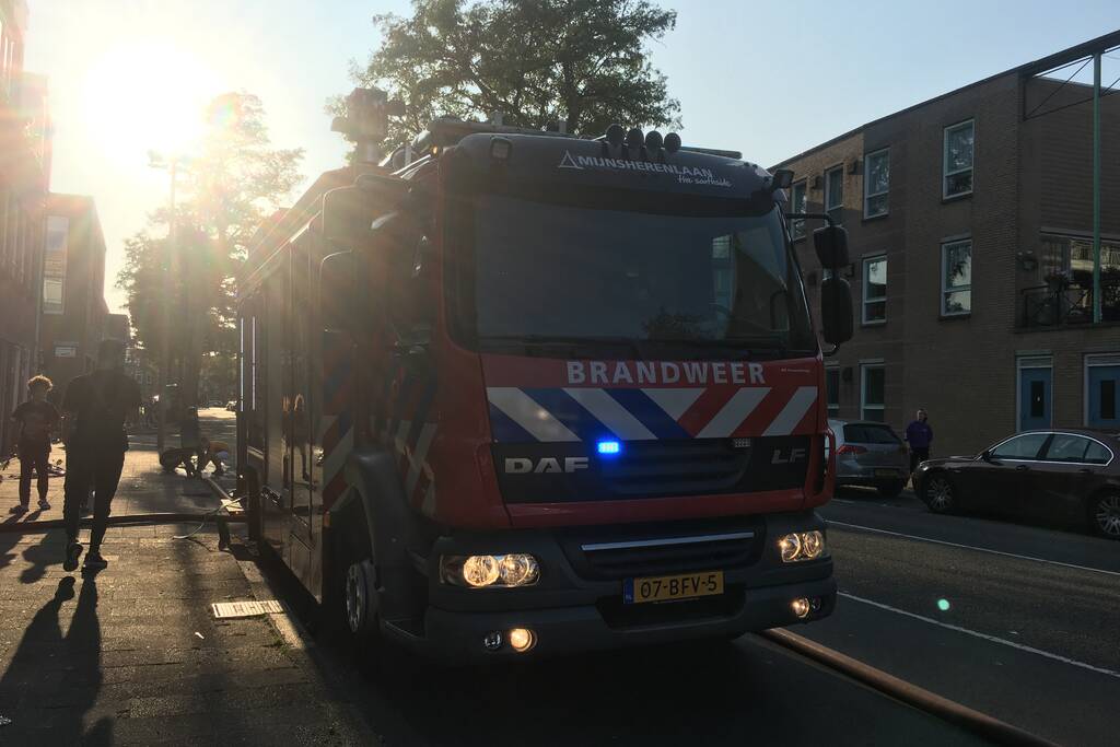 Boom achter woonblok vliegt in brand