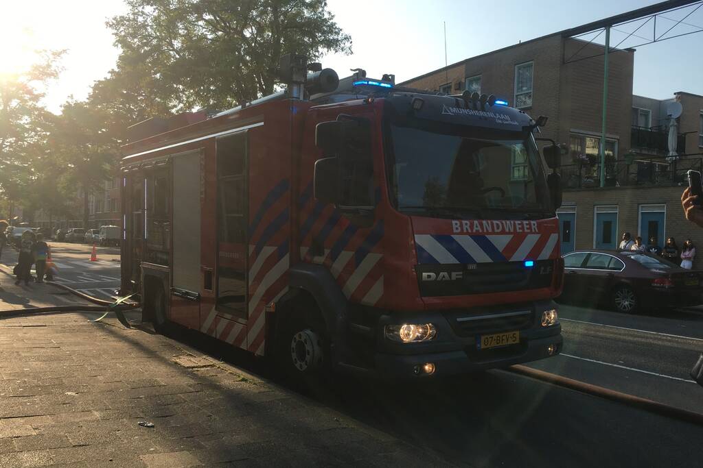 Boom achter woonblok vliegt in brand