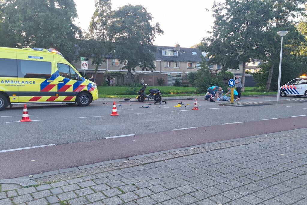 Taxi en scooter botsen op kruising