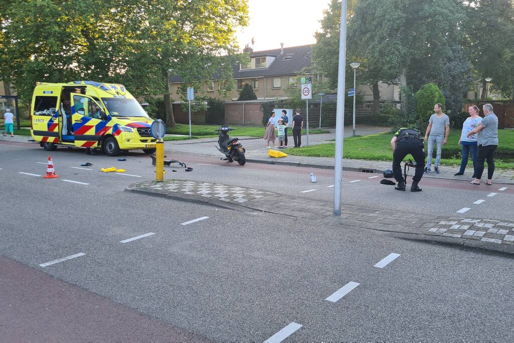 Taxi en scooter botsen op kruising