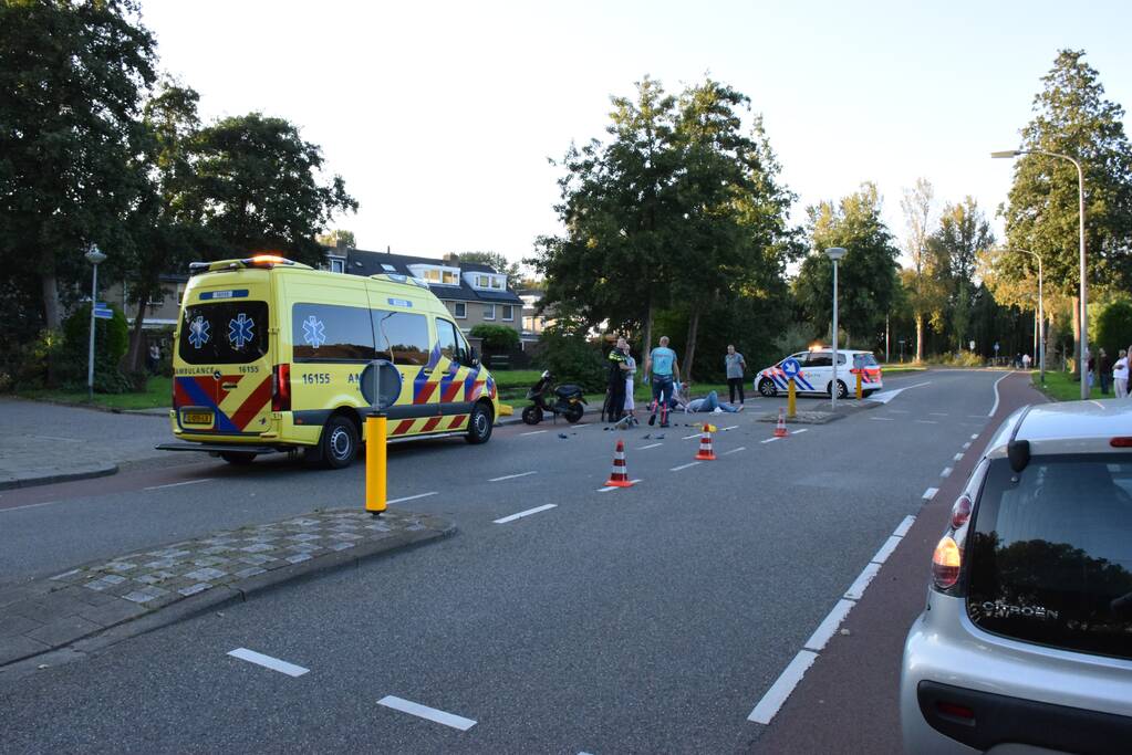 Taxi en scooter botsen op kruising