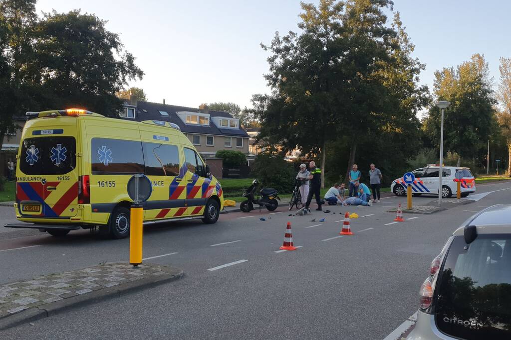 Taxi en scooter botsen op kruising