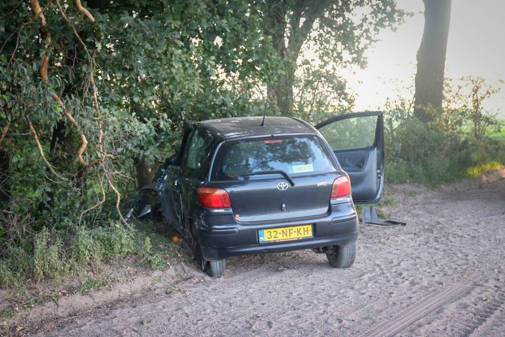 Auto raakt van zandpad en botst op boom