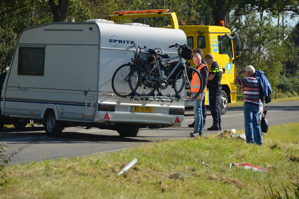 Auto met caravan raakt van de weg